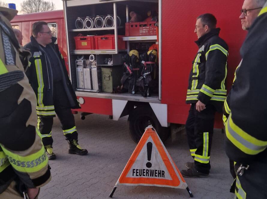 Erklärung von Absperr-Utensilien vor einem Feuerwehrfahrzeug