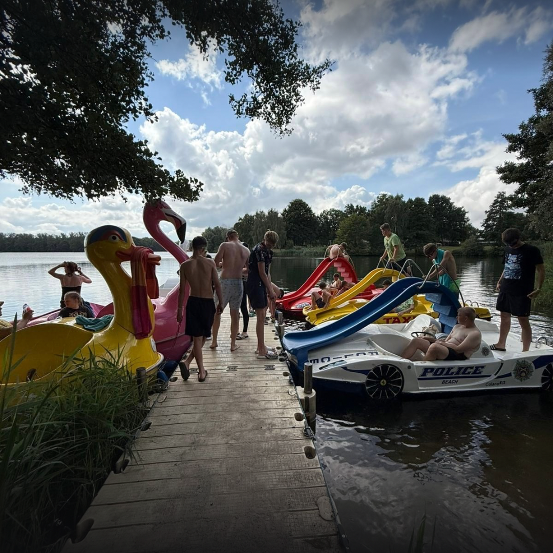 Kinder an einem See mit Tretbooten