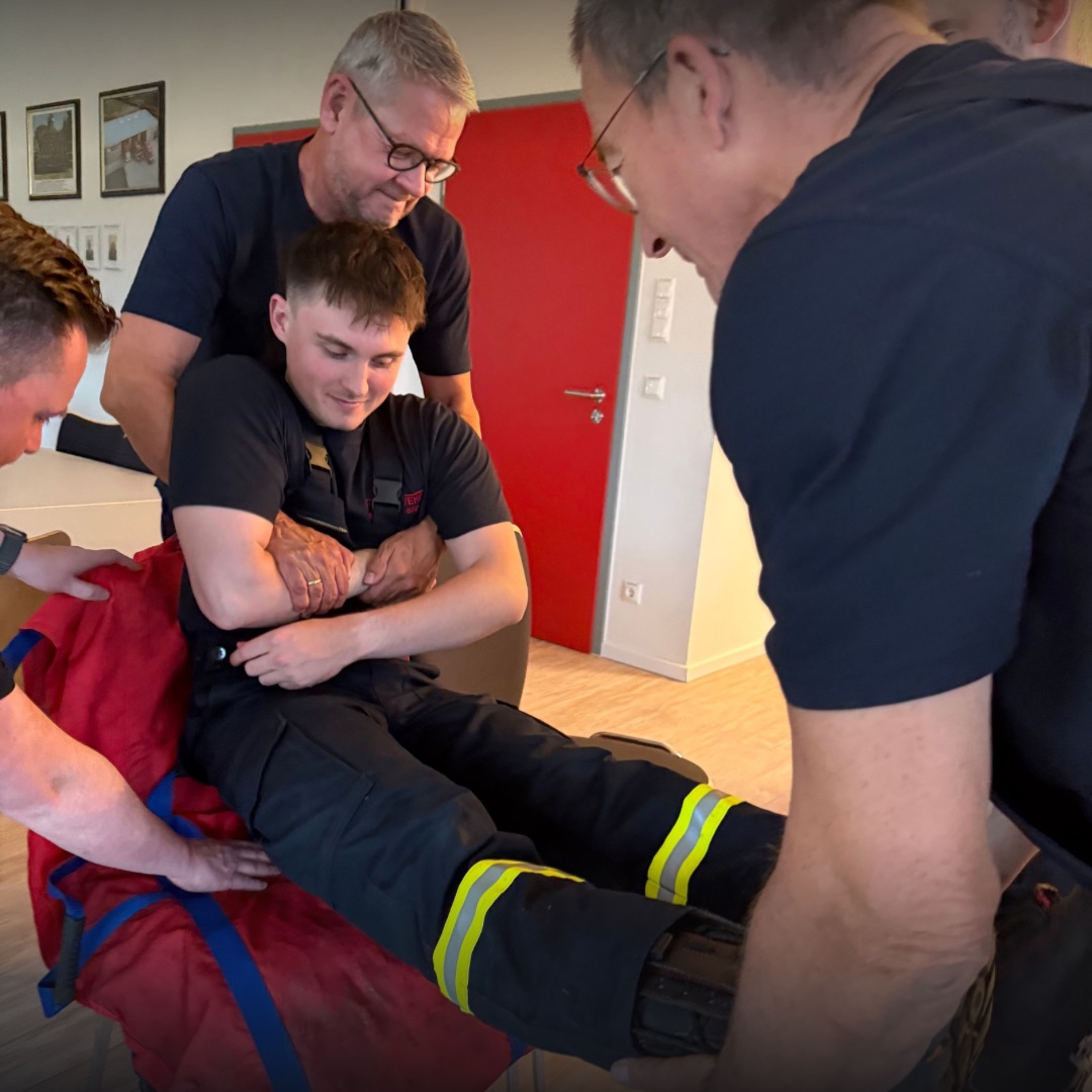 Eine Person wird in ein Tuch gesetzt