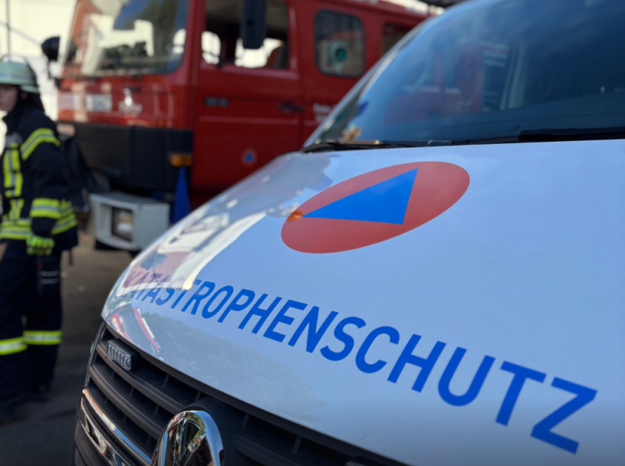 Ein Fahrzeug des Katastrophenschutzes und ein Feuerwehrfahrzeug im Hintergrund