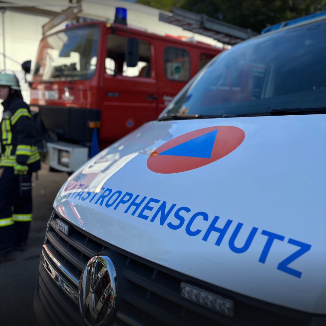 Ein Fahrzeug des Katastrophenschutzes und ein Feuerwehrfahrzeug im Hintergrund
