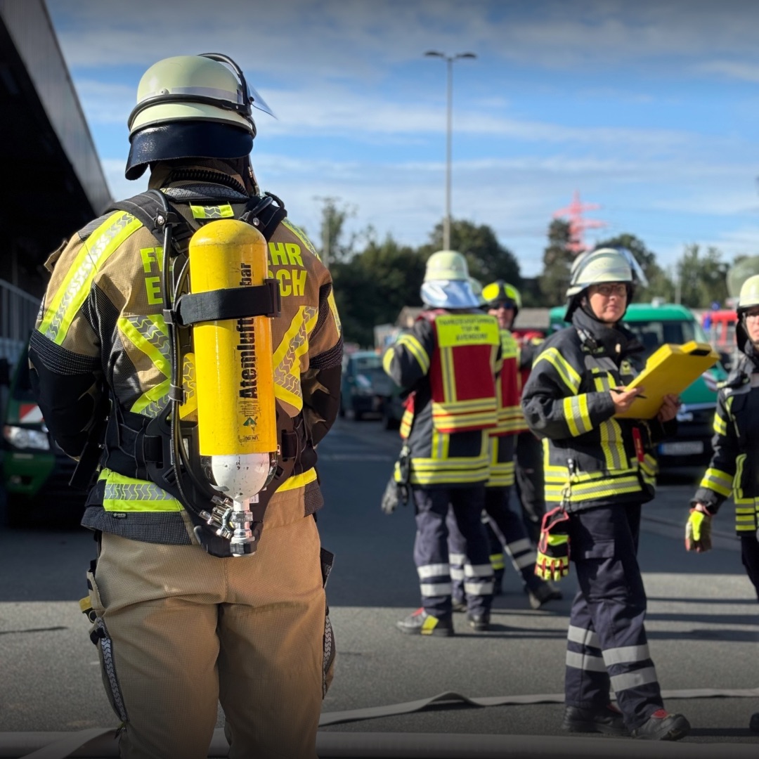 Feuerwehrleute stehen auf einer Straße