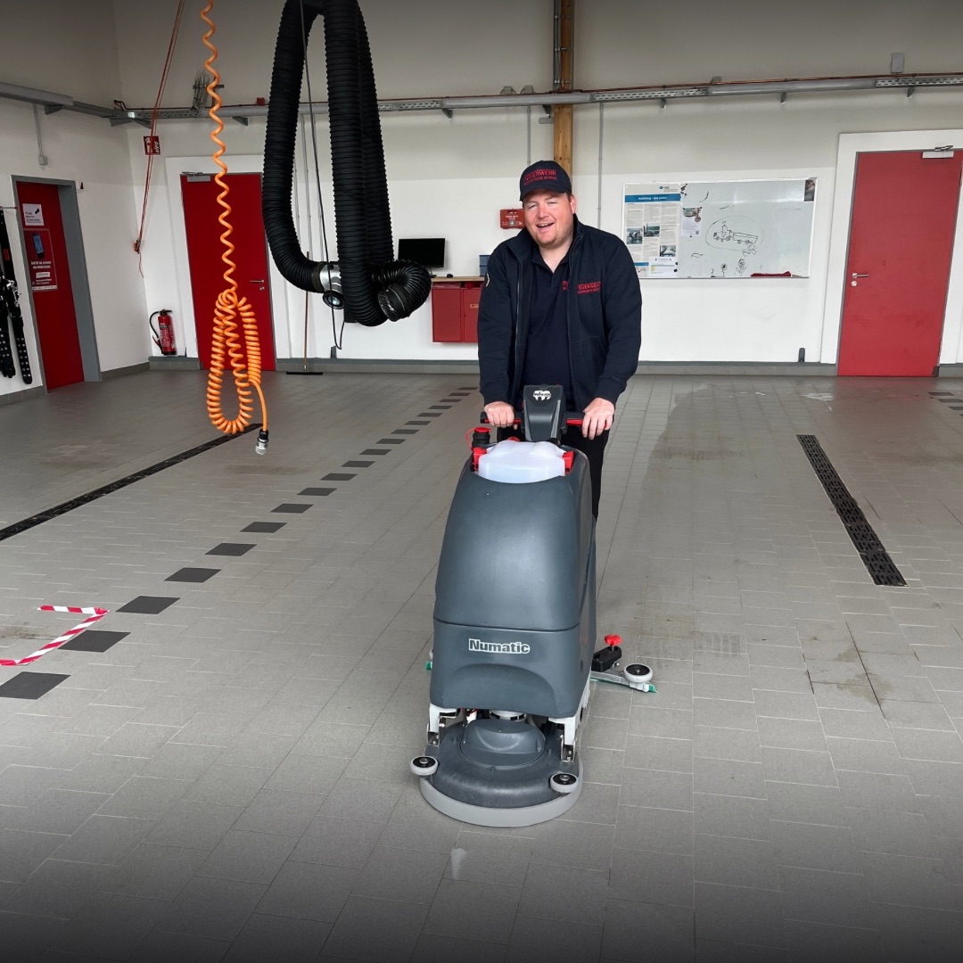 Die Fahrzeughalle wird mit einer Maschine gereinigt