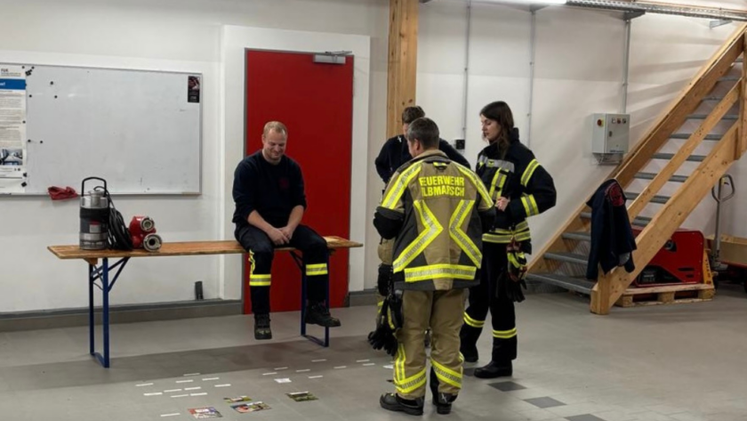 Feuerwehrleute in einer Fahrzeughalle