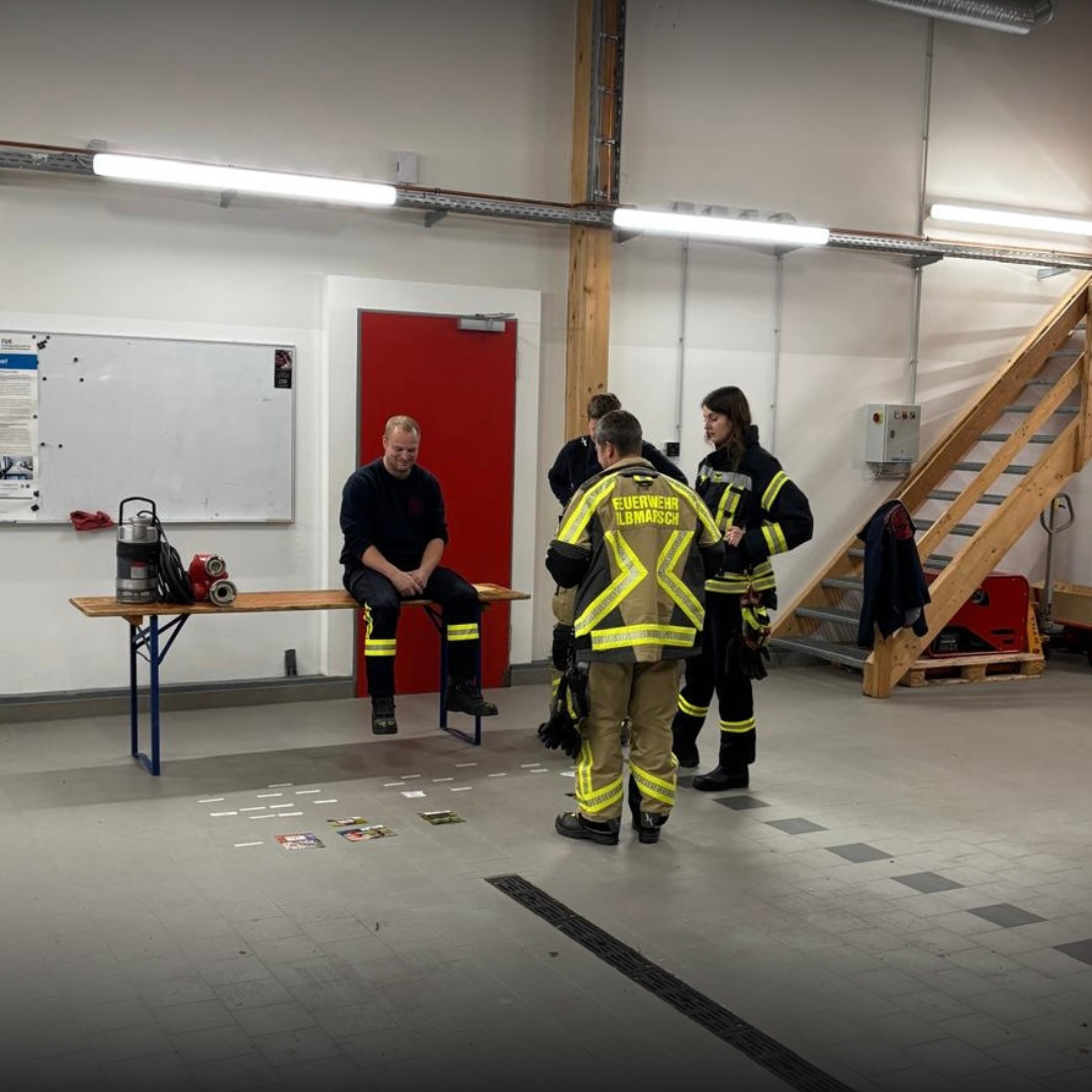 Feuerwehrleute in einer Fahrzeughalle