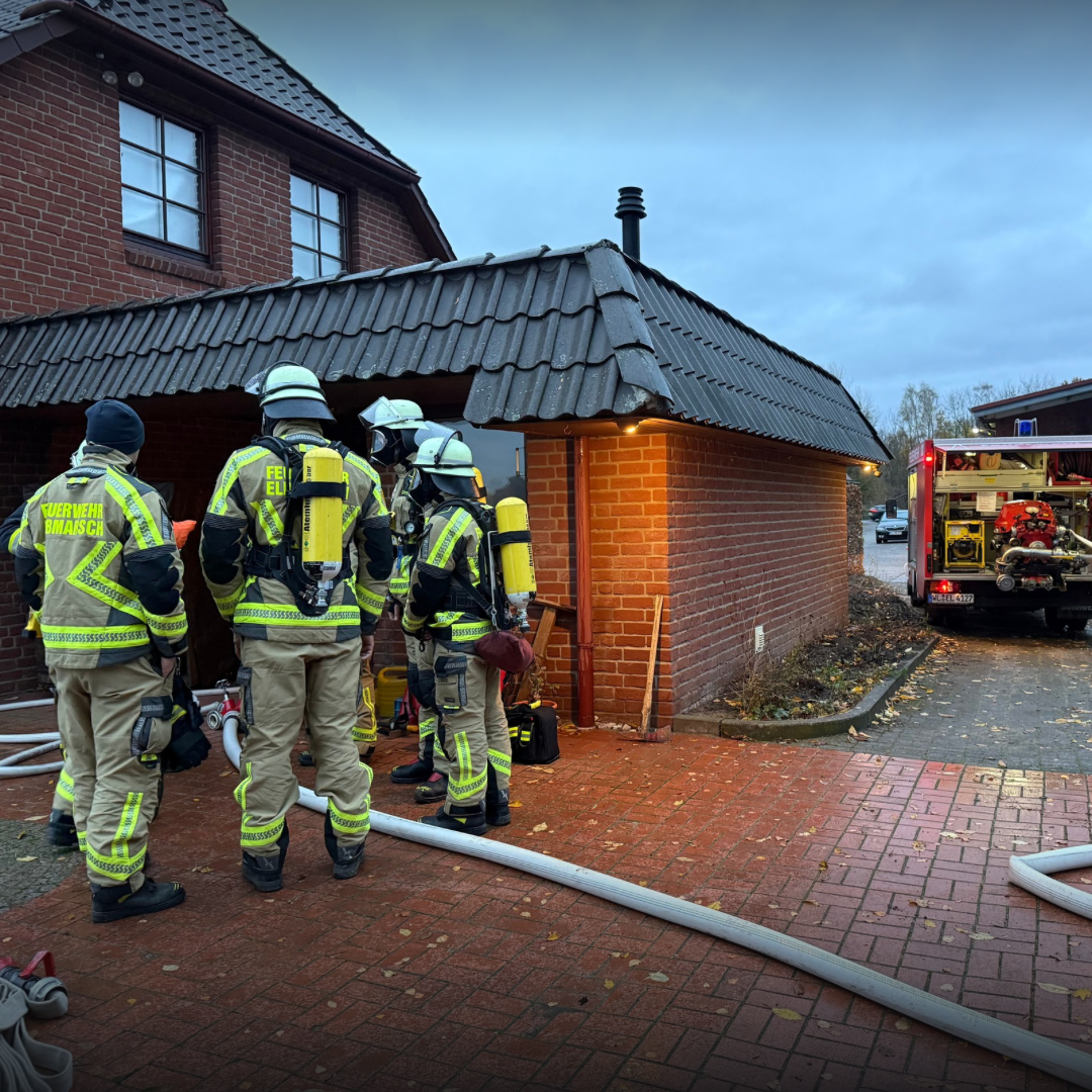 Atemschutzträger vor einem Haus aus dem Rauch kommt
