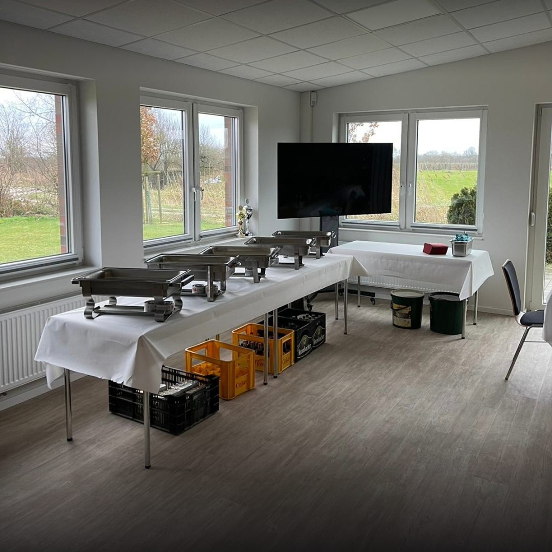 Ein Buffet auf einem Tisch mit einem Fernseher im Hintergrund