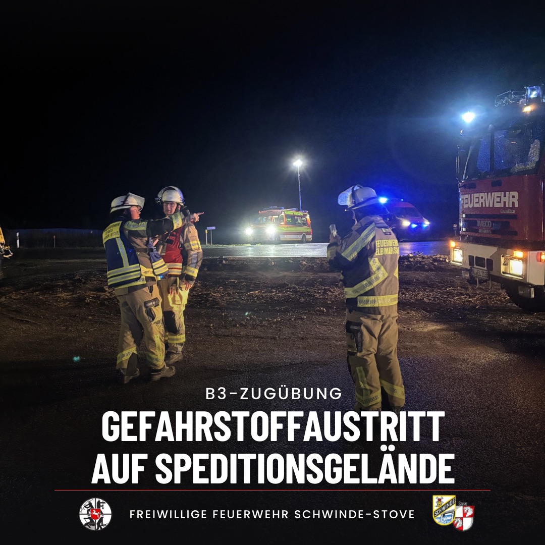 Einsatzkräfte besprechen sich vor mehreren Einsatzfahrzeugen