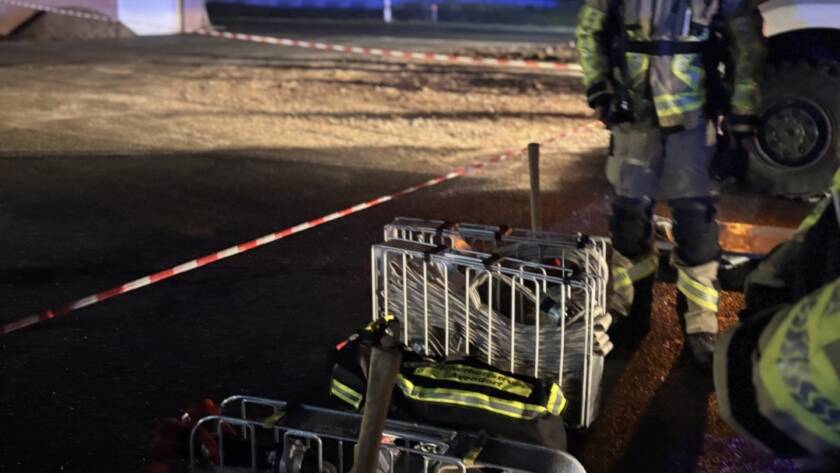 Schlauchkörbe und Einsatzkräfte in Bereitstellung hinter einer Absperrung