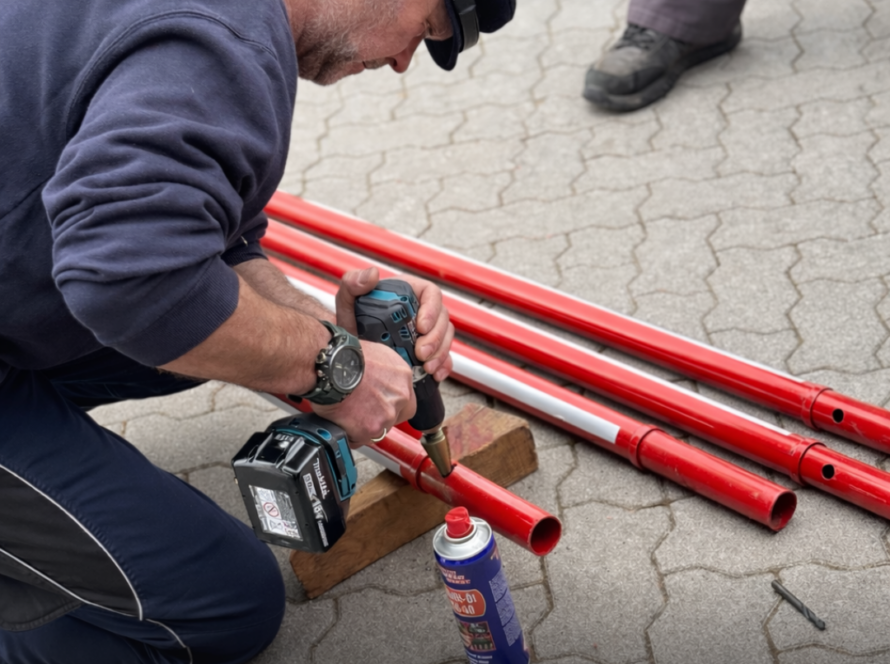 Ein Mann bohrt Löcher in eine Stange