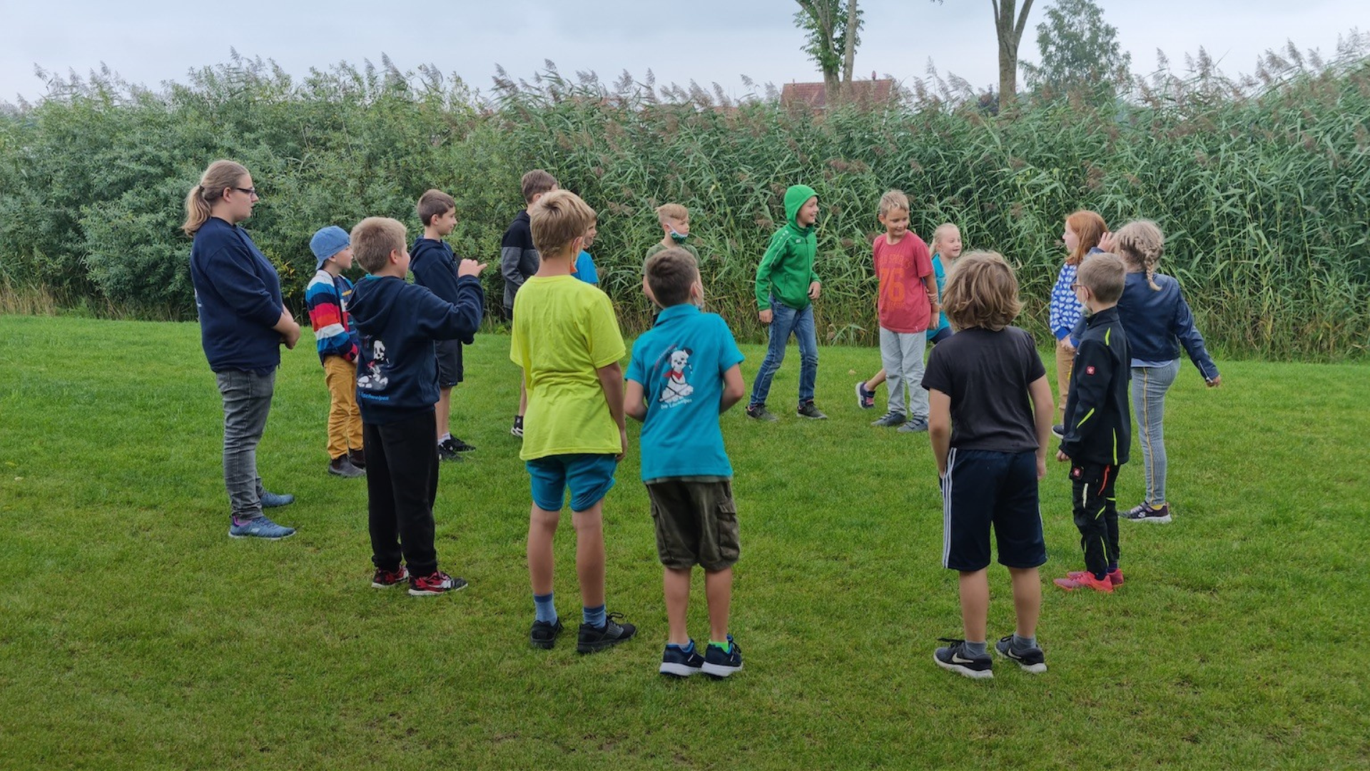 Kinder stehen im Kreis und spielen