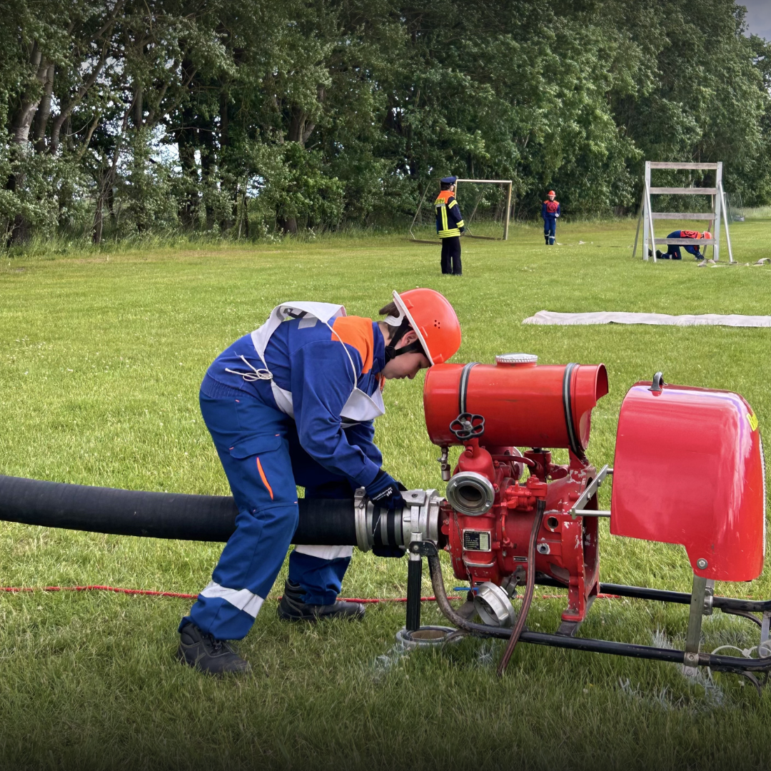 Jugendfeuerwehr kuppelt Saugleitung an Pumpe