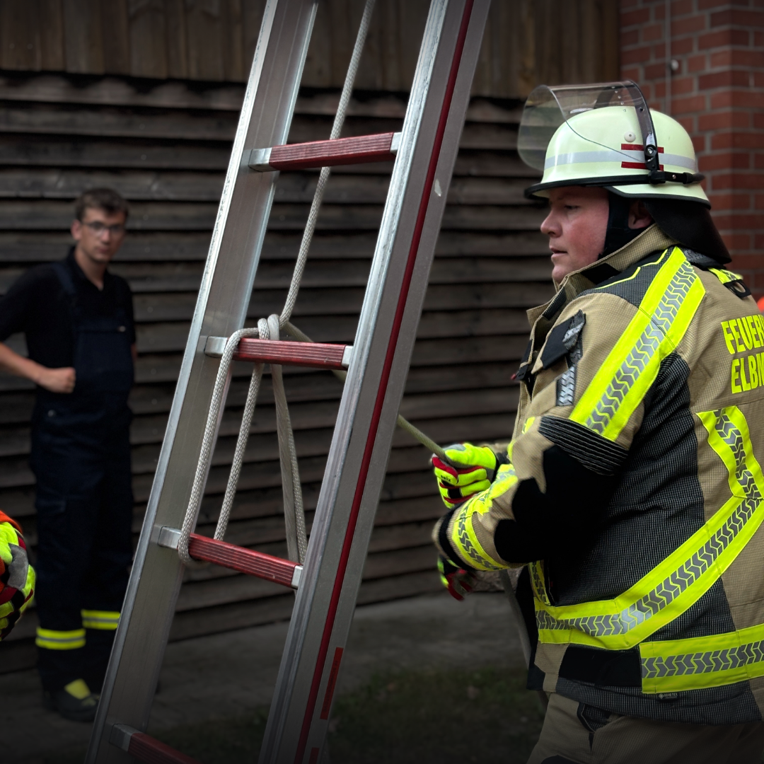 Feuerwehrleute bauen eine Leiter auf