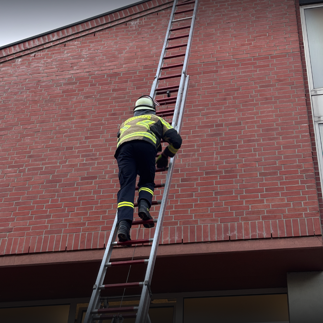 Feuerwehrmann geht eine Leiter hinauf