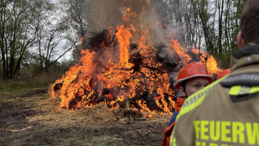 Ein brennendes Feuer und Menschen im Vordergrund