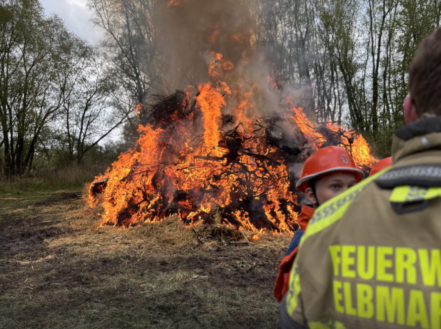 Ein brennendes Feuer und Menschen im Vordergrund