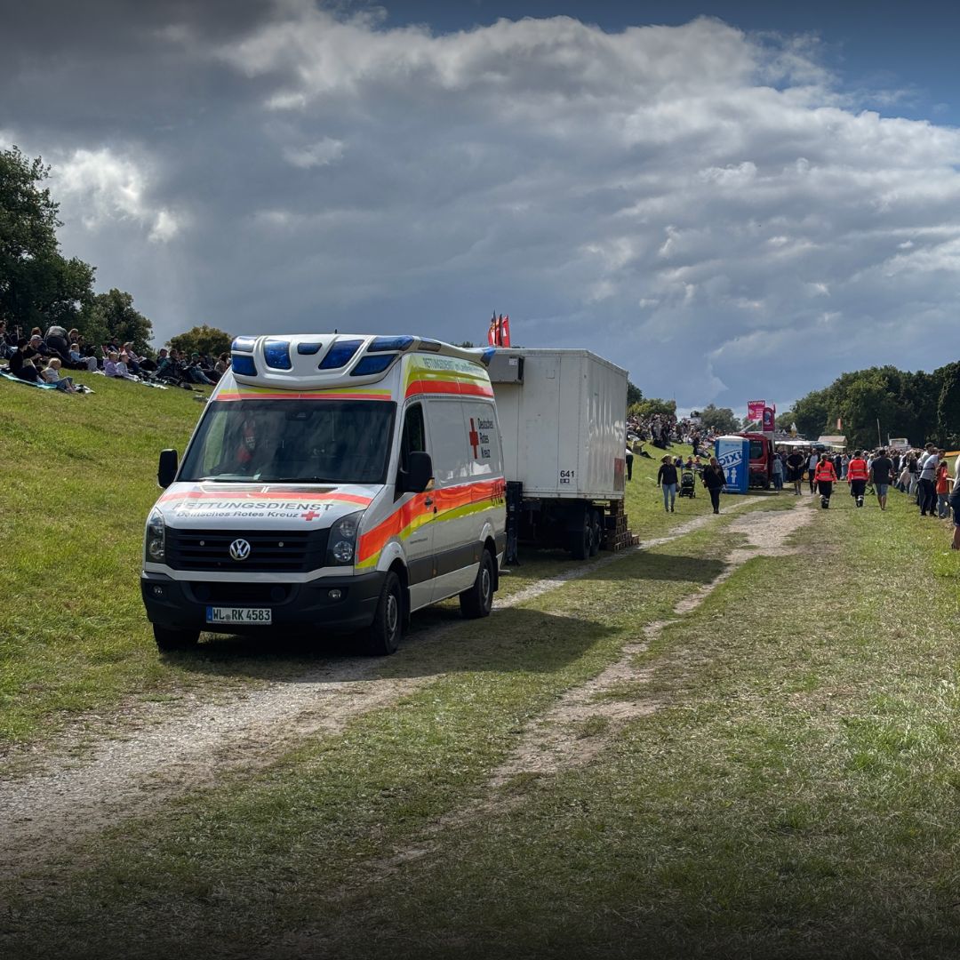 Rettungswagen steht auf einer Wiese am Veranstaltungsgelände