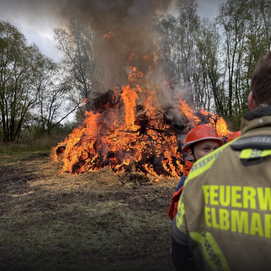 Ein brennendes Feuer und Menschen im Vordergrund