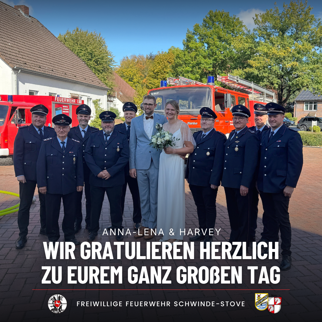 Brautpaar mit Feuerwehrkameraden vor den Feuerwehrfahrzeugen